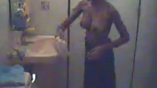 Mature housewife taking her clothes off in shower